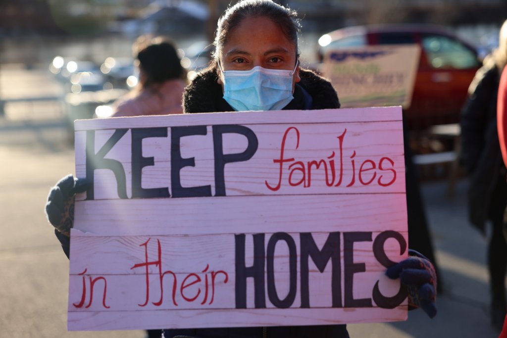 Person holding sign that says `keep families in their homes`