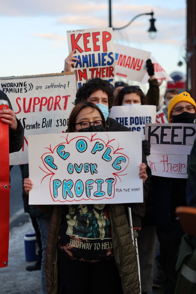Person at a Good Cause Eviction Rally holding a sign that says